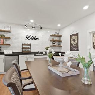 A modern kitchen and dining area featuring a wooden table, open shelves, and elegant decor.