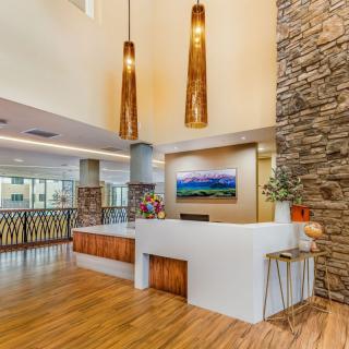 A modern reception area featuring wood flooring, decorative lighting, and a stone accent wall.