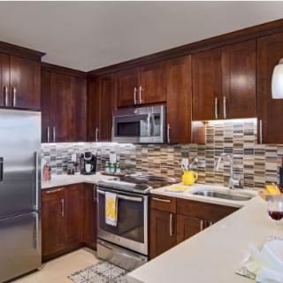 A modern kitchen with dark brown cabinets and stainless steel appliances.