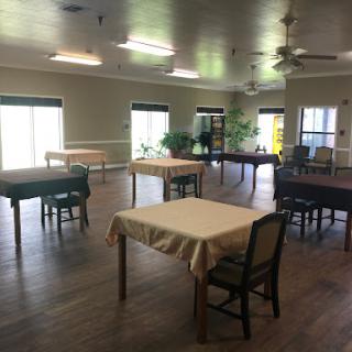 A spacious and inviting dining area with tables set for meals, illuminated by natural light.