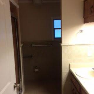 A small bathroom with a sink, mirror, and towel bar.