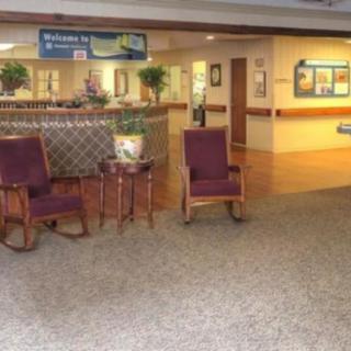 A hospital waiting area with chairs and a reception desk.
