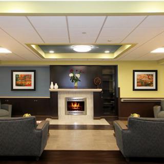 A modern lobby with comfortable seating, a fireplace, and decorative artwork on the walls.