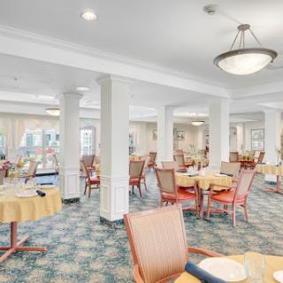 A spacious and well-lit dining area featuring comfortable seating and elegant decor.