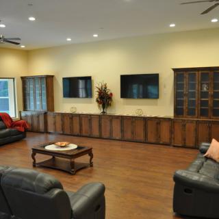 A modern living room with multiple televisions and comfortable seating.