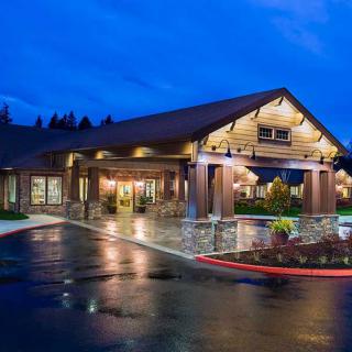 A warmly lit building with log cabin architecture at night.