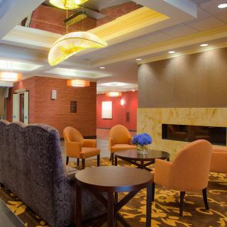 A modern hotel lobby with comfortable seating and a fireplace.