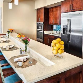 A modern kitchen with a sleek countertop adorned with lemons and set for dining.