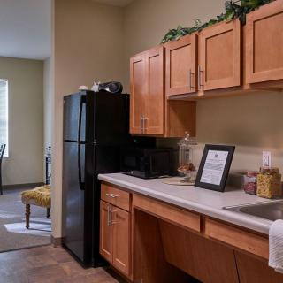 A cozy kitchen space with wooden cabinets and a black refrigerator.