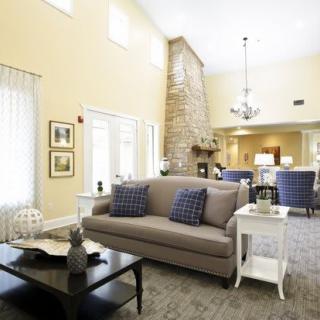 A spacious and well-lit living room featuring comfortable seating, a fireplace, and elegant decor.