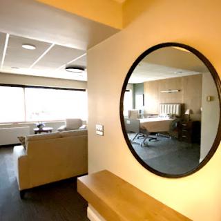 A modern living space featuring a stylish mirror and comfortable seating area.