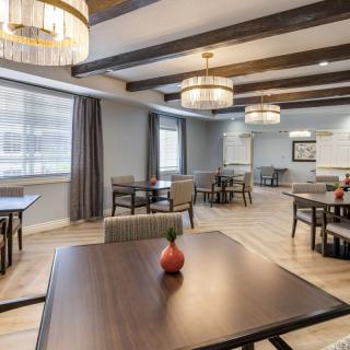 A modern dining room with neatly arranged tables and stylish lighting fixtures.