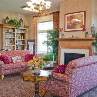 A cozy living room with patterned sofas, a fireplace, and elegant decor.