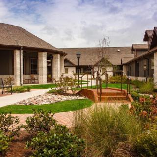 A serene garden landscape featuring well-maintained pathways and lush greenery.