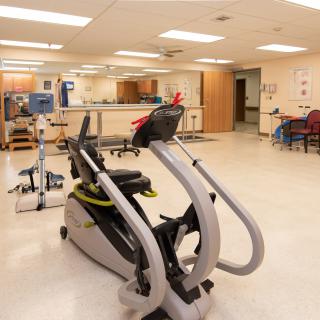 A rehabilitation room equipped with exercise machines and medical equipment.