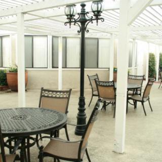 A patio area featuring tables and chairs under a pergola.
