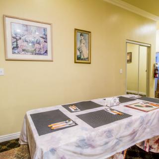 A dining area with a table set with placemats and wall art decorations.