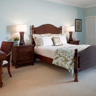 A beautifully designed bedroom featuring elegant wooden furniture and soft blue walls.