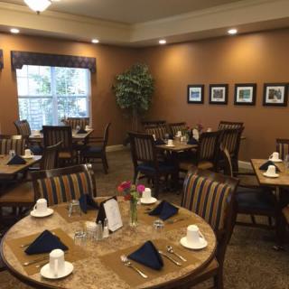 A cozy dining room with neatly set tables and warm lighting.