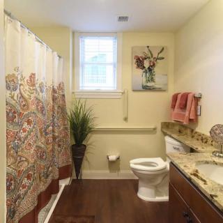 A well-lit bathroom with a colorful shower curtain and decorative elements.