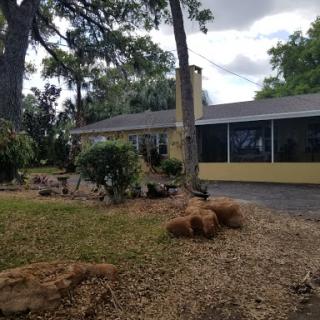 A charming residential house surrounded by greenery and well-maintained landscaping.