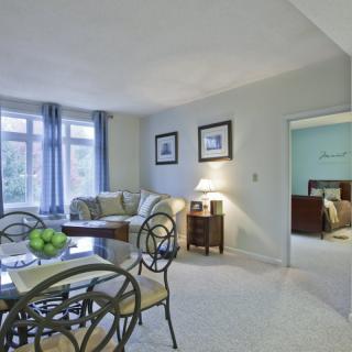 A cozy living room with a dining area, featuring stylish furniture and ample natural light.