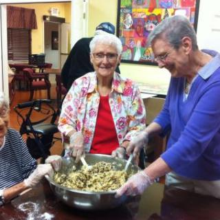 A group of elderly women enjoying a cooking activity together.