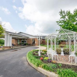 A well-maintained building entrance with a decorative gazebo and landscaped garden.