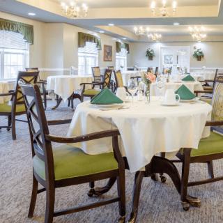 An elegantly set dining room with neatly arranged tables and chairs.