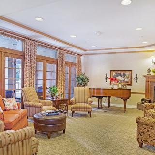 A spacious living room featuring a piano and cozy seating arrangement.