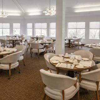 An elegant dining room with neatly set tables and comfortable chairs.
