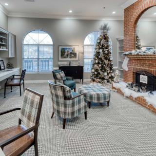 A cozy living room adorned with festive holiday decorations, featuring a Christmas tree and a warm fireplace.