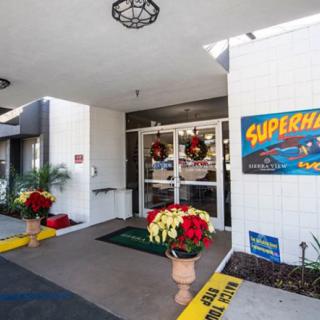 The entrance of a building decorated with wreaths and poinsettias for the holiday season, featuring visible signage.