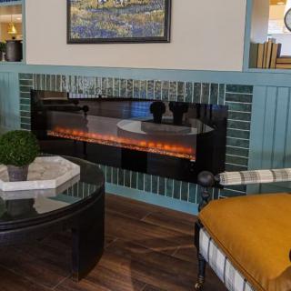 A cozy living room with a modern electric fireplace and stylish decor.