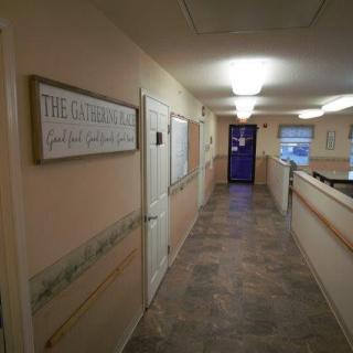 A well-lit indoor hallway with a sign on the wall.