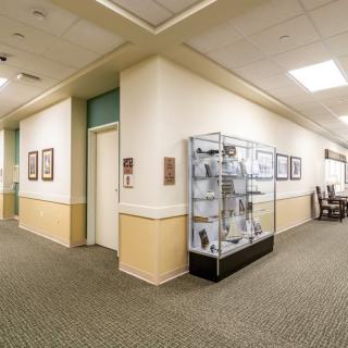 A well-lit hallway with a museum display showcasing various artifacts.