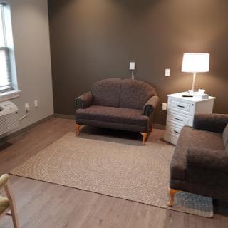 A cozy living room setup featuring a comfortable sofa, a side table with a lamp, and a stylish rug.