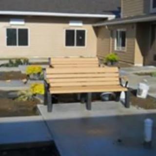 A courtyard featuring several wooden benches and a small garden area.