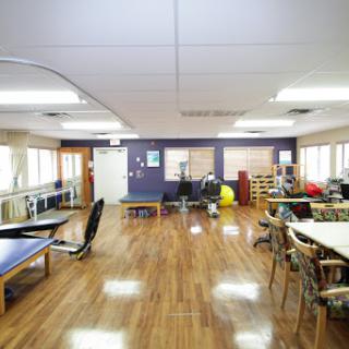 A spacious and well-lit classroom or community workspace featuring various furniture arrangements.