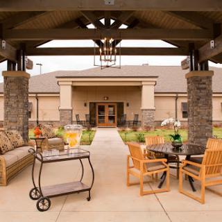 A cozy outdoor seating area leading to a welcoming building entrance, perfect for relaxation.
