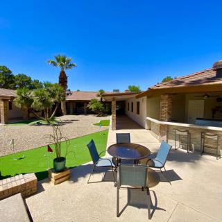 A sunny courtyard with outdoor seating and lush palm trees.