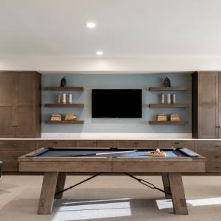 Modern game room with a billiard table and entertainment setup.