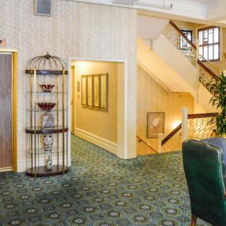 A cozy hallway with carpeted flooring, decorative elements, and a staircase.