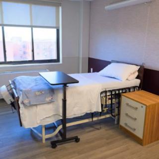 A hospital room with a bed and bedside table.