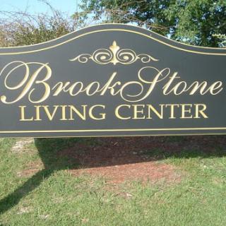 Sign for the BrookStone Living Center, set in an outdoor landscape.