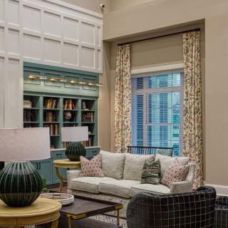 A cozy living room with a comfortable sofa, bookshelves, and stylish lamps.