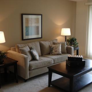 A cozy living room with a neutral-colored sofa, coffee table, and warm lighting.