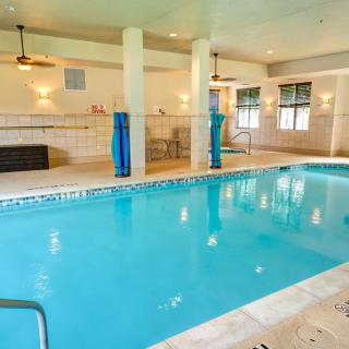 An inviting indoor swimming pool with clear blue water, surrounded by a bright and spacious environment.
