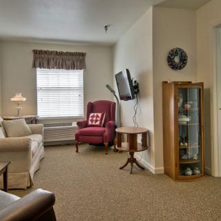 A cozy living room with comfortable seating and a wall-mounted television.