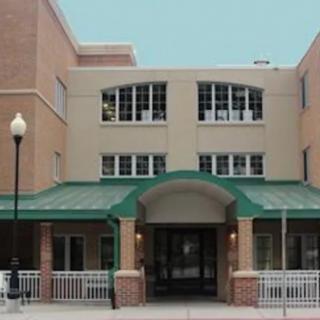 A three-story building with a green awning and multiple windows.